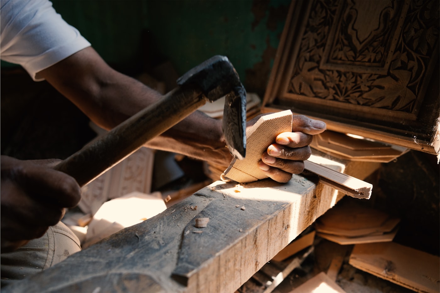 Hände eines Handwerkers bei präziser Arbeit an einem Holzbalken