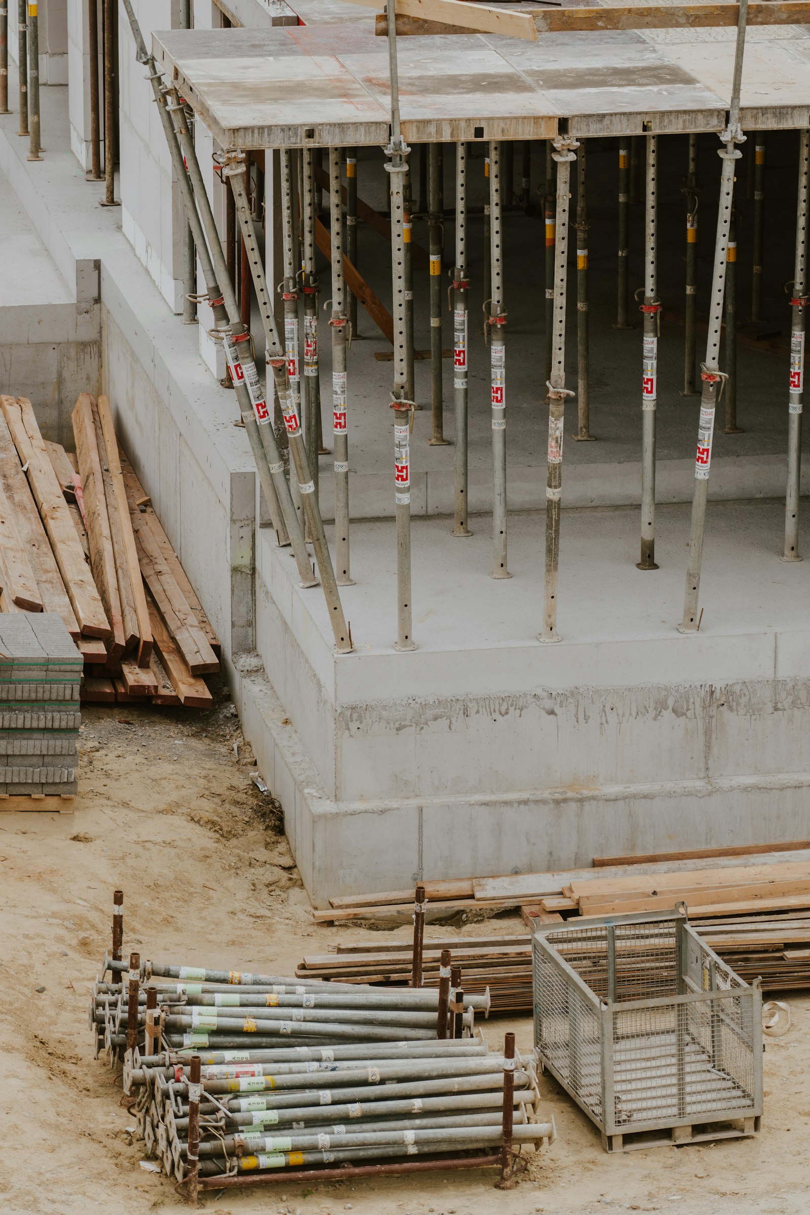 Frisch betoniertes Kellerfundament mit Schalungsstützen auf einer Baustelle